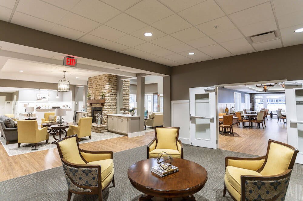 A cozy and modern lobby area featuring comfortable chairs and a central table.