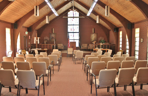 A spacious interior of a community gathering space, set up with chairs for an event.