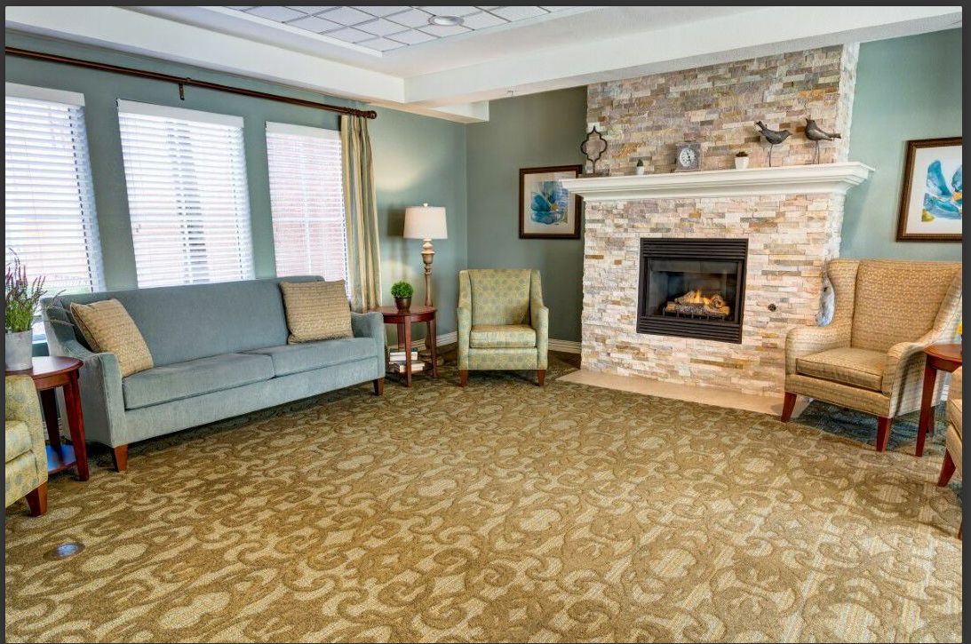 A cozy living room with a fireplace, sofa, and armchair.