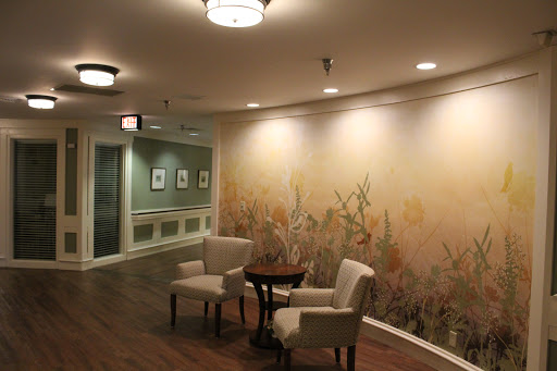 A serene waiting area featuring two chairs and a decorative wall mural.