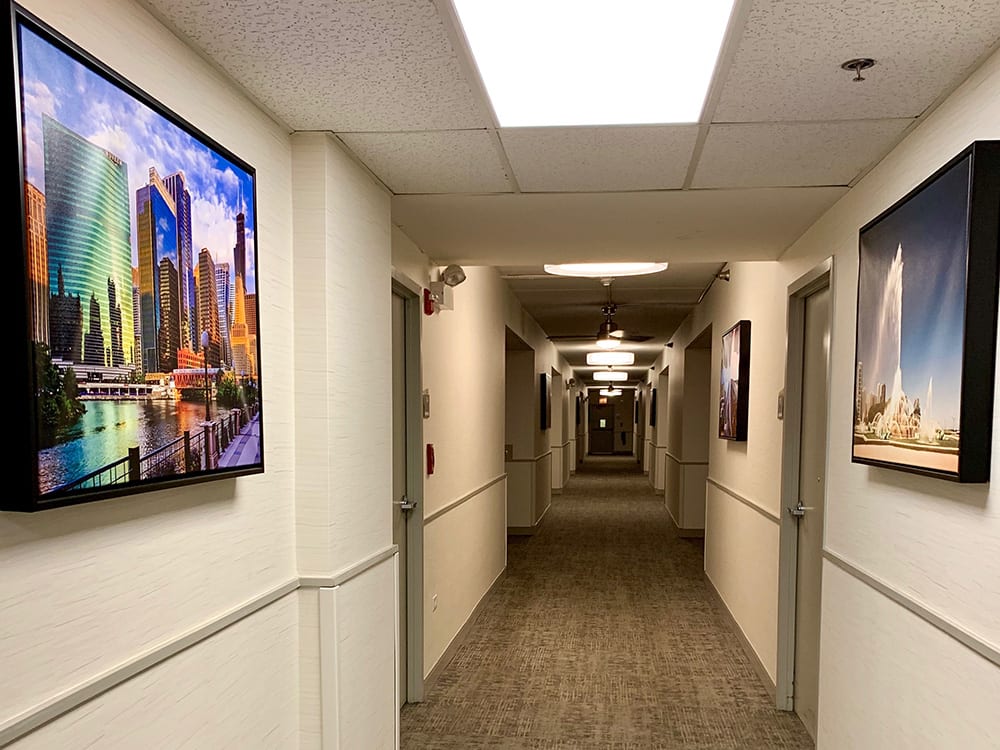 A well-lit hallway decorated with framed artwork on the walls.