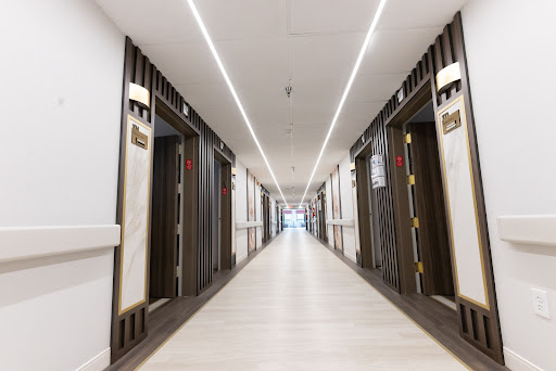 A modern hotel corridor featuring elevators and sleek lighting.