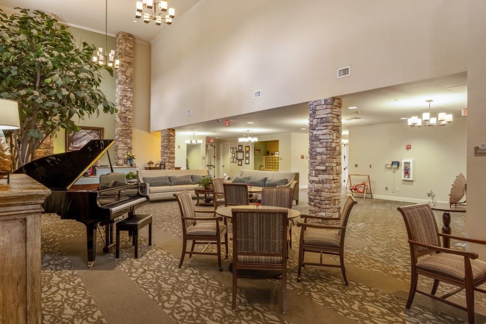 A spacious lobby with a grand piano, comfortable seating, and elegant lighting.