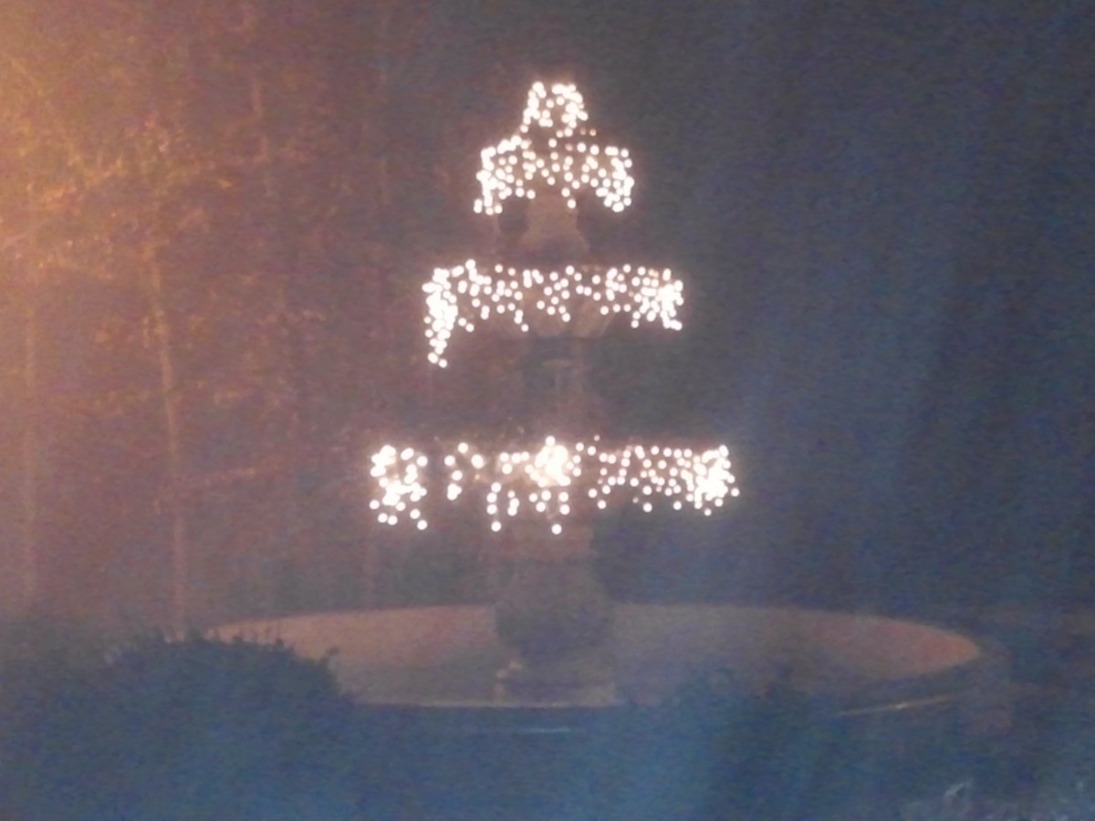 A beautifully lit fountain at night with cascading lights.