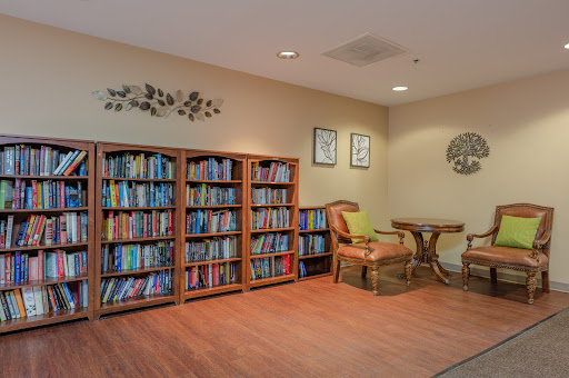 A cozy reading corner featuring a bookshelf filled with colorful books, comfortable seating, and decorative elements.
