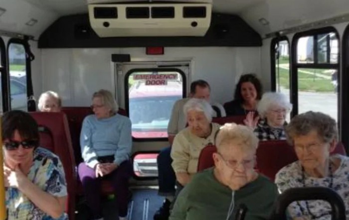A group of seniors seated inside a bus.