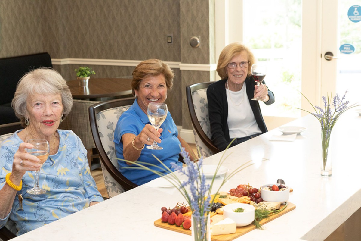 A group of women enjoying a celebratory gathering with drinks and food.