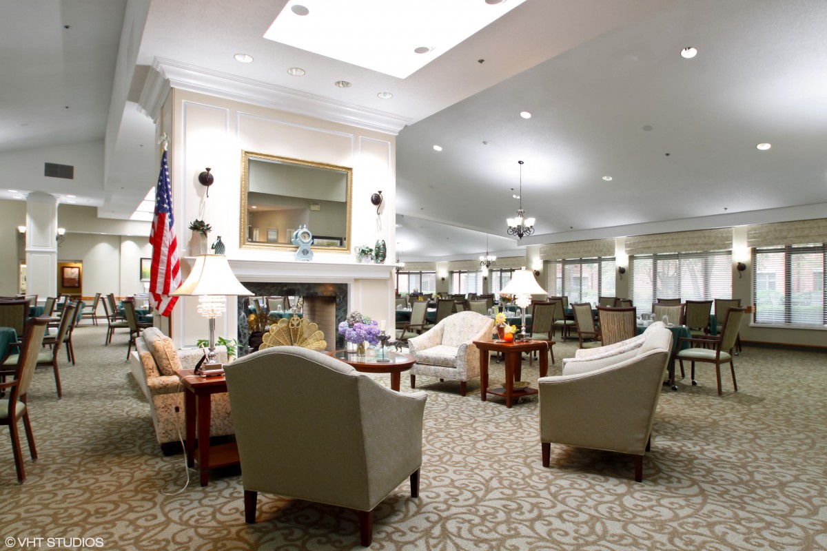 A spacious and well-lit lounge area with comfortable seating and a fireplace.
