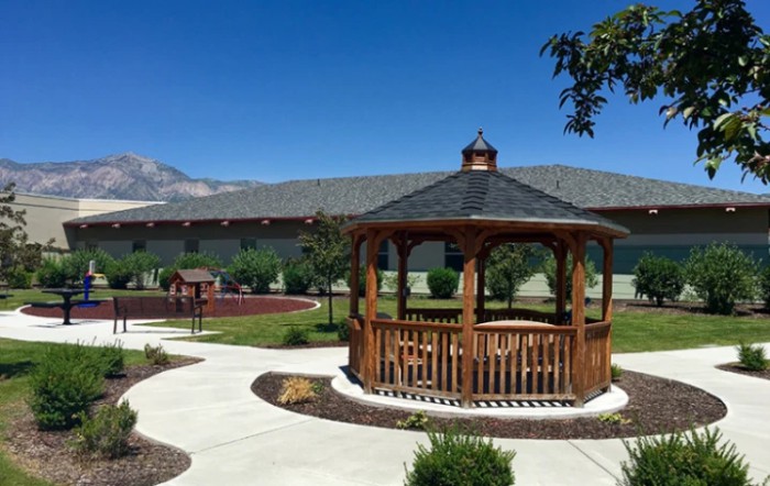 A beautifully landscaped garden featuring a wooden gazebo and winding pathways.