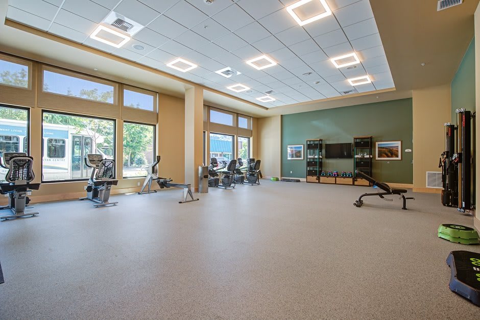 A modern fitness center with exercise equipment and bright lighting.