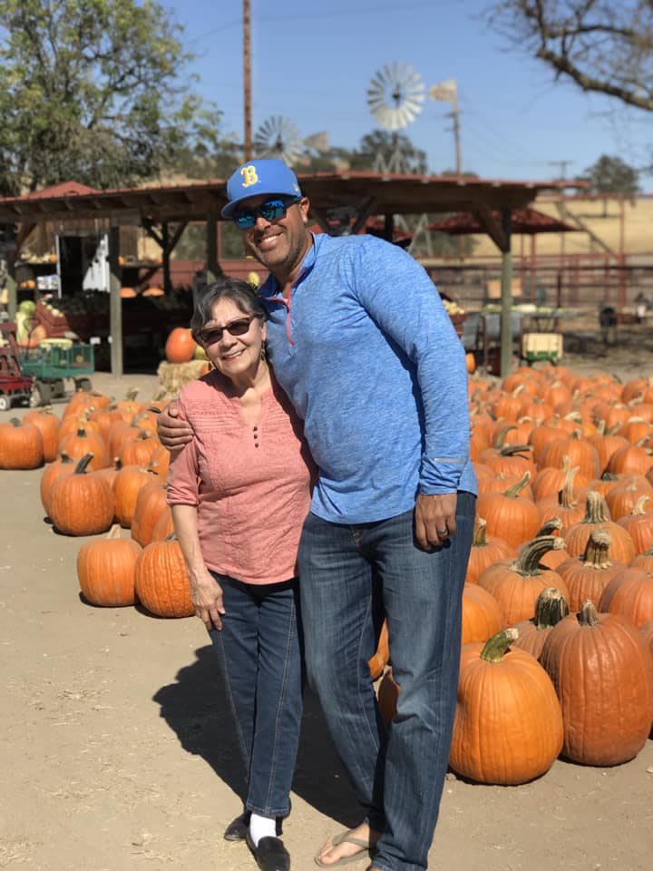 A couple enjoying a sunny day at a pumpkin patch.