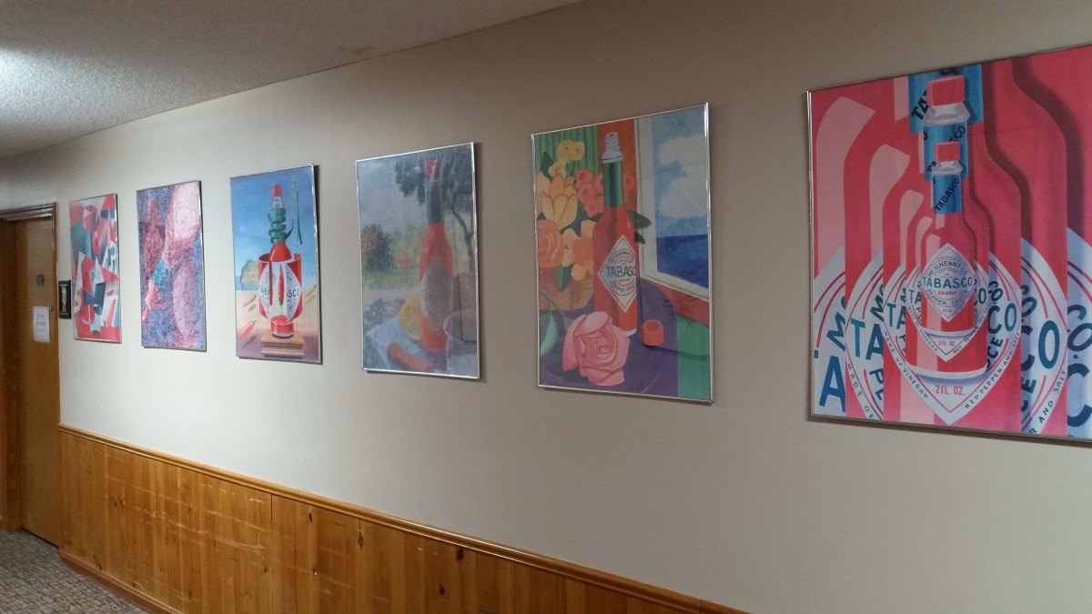 A hallway featuring a series of colorful paintings displayed on the wall.