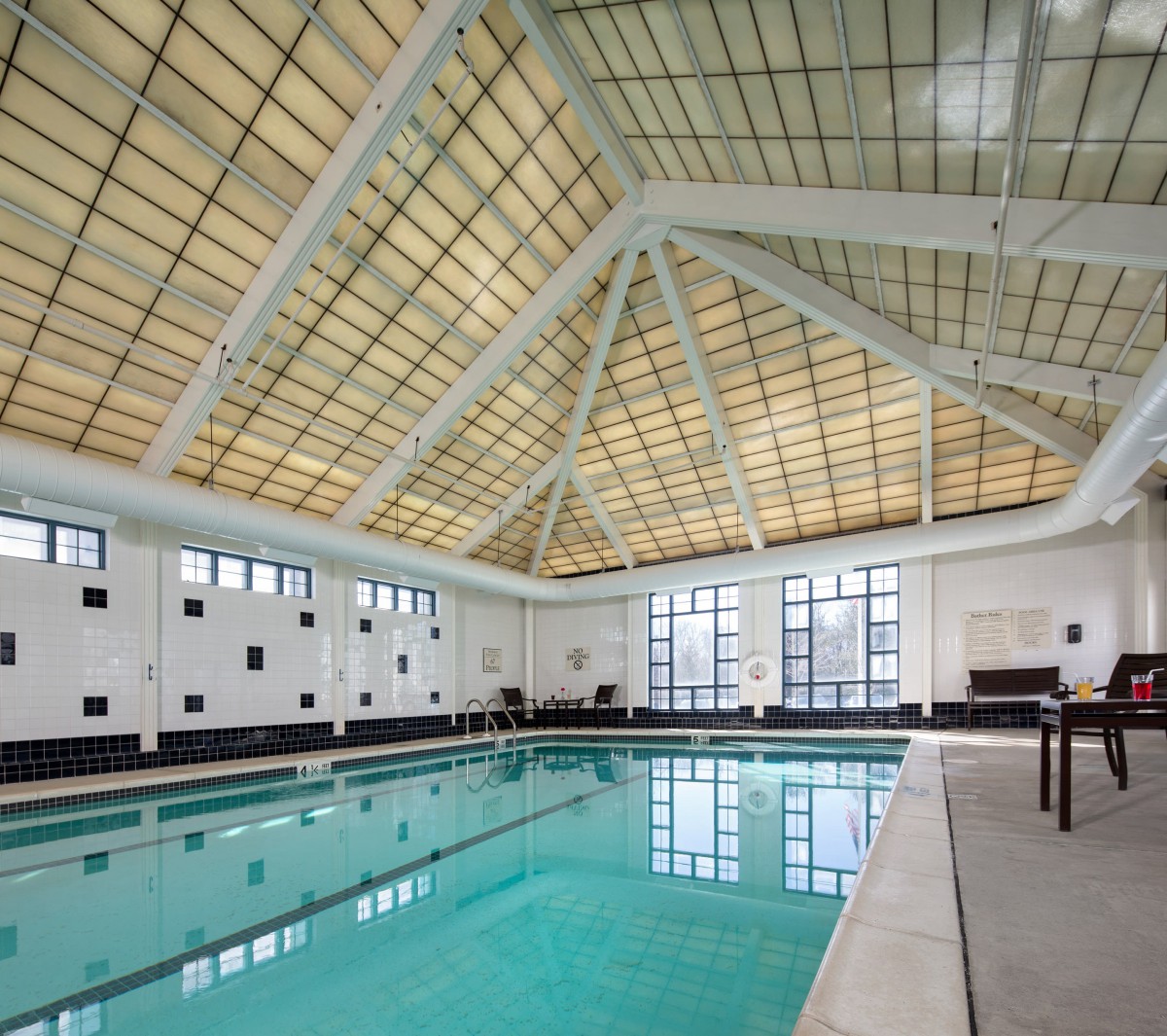 An indoor swimming pool with a large skylight ceiling and modern architecture.