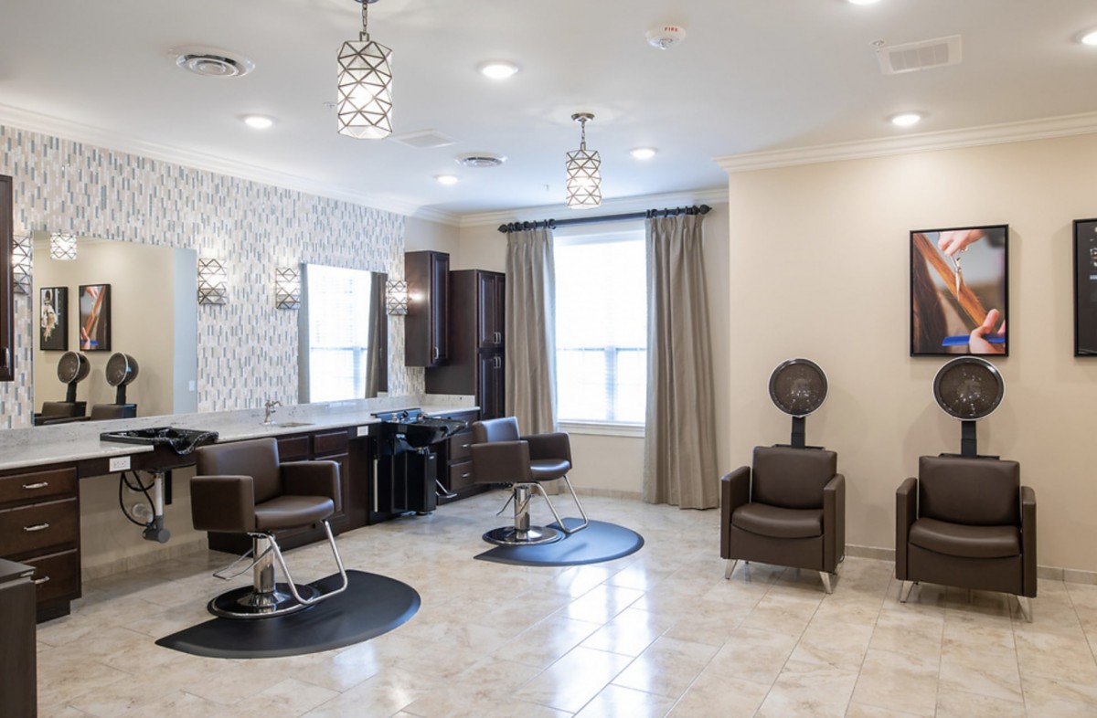 A modern and luxurious salon interior with stylish chairs and large mirrors.