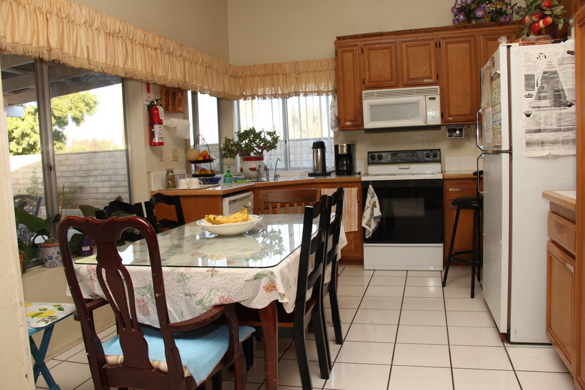 A cozy kitchen with a dining table and various appliances.