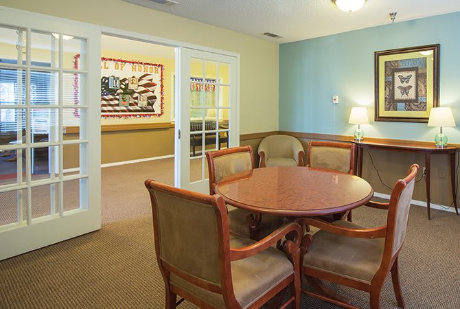 A cozy dining area with a wooden table and chairs, featuring wall artwork and soft lighting.