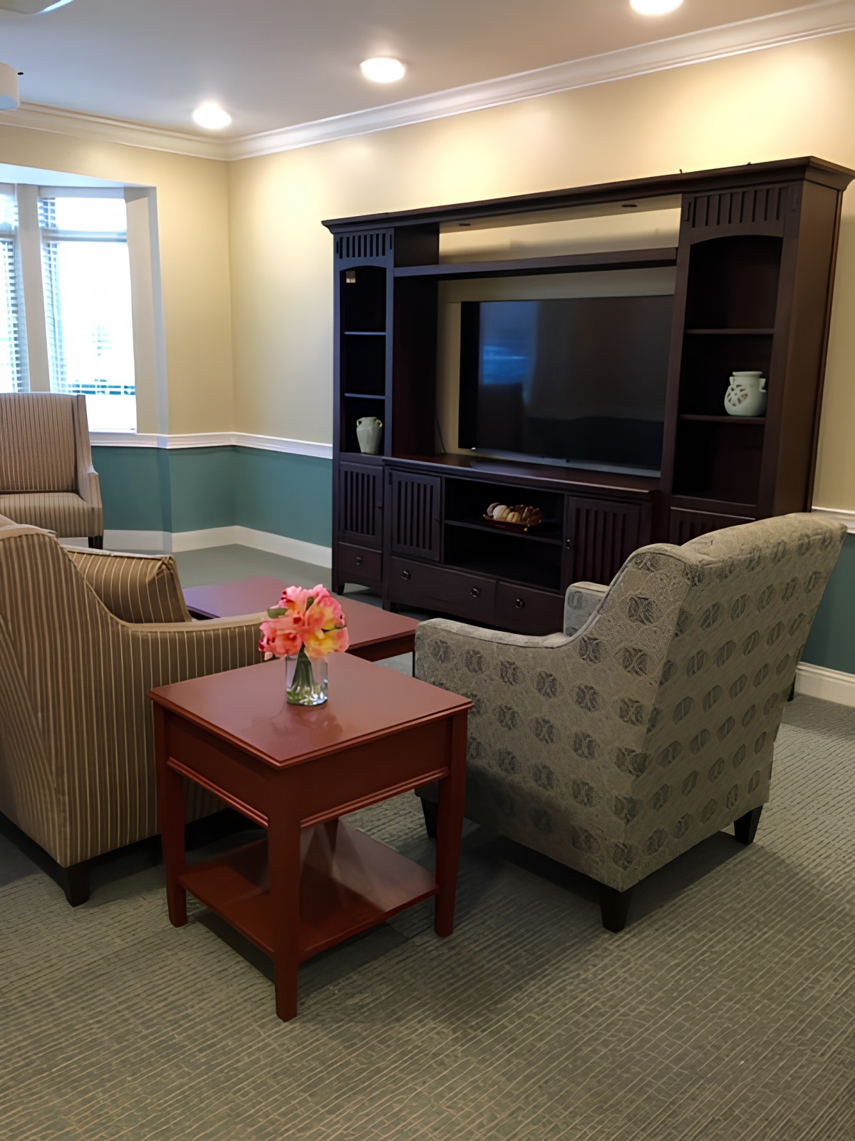A cozy living room setup with chairs, a table, and a television.