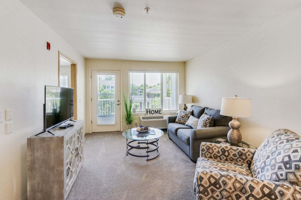 A cozy and modern living room with comfortable seating and ample natural light.