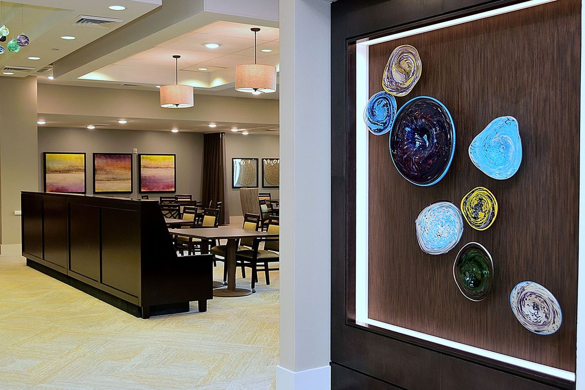 A modern dining area with artistic wall decorations and elegant lighting.