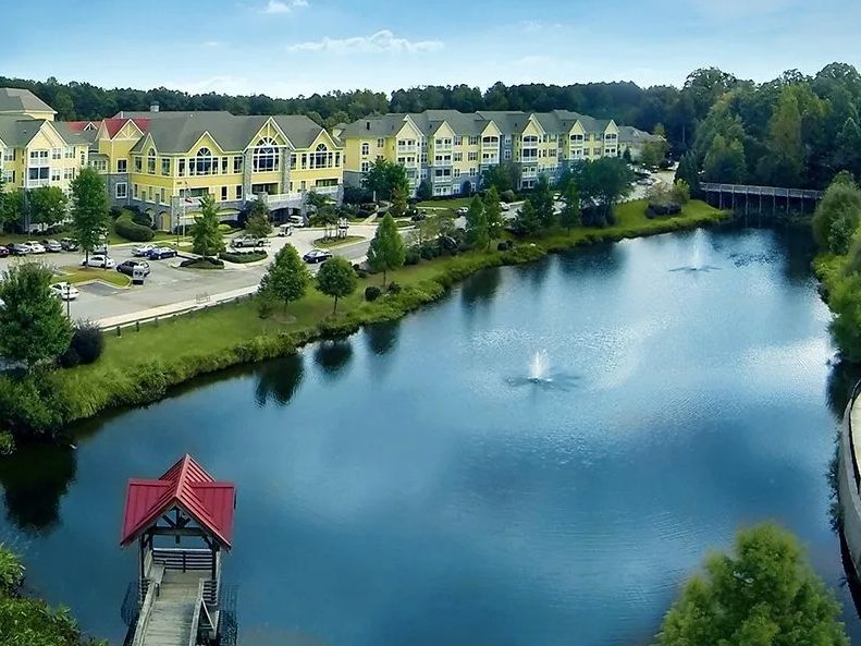 A scenic aerial view of a waterfront residential area with fountains in the lake.