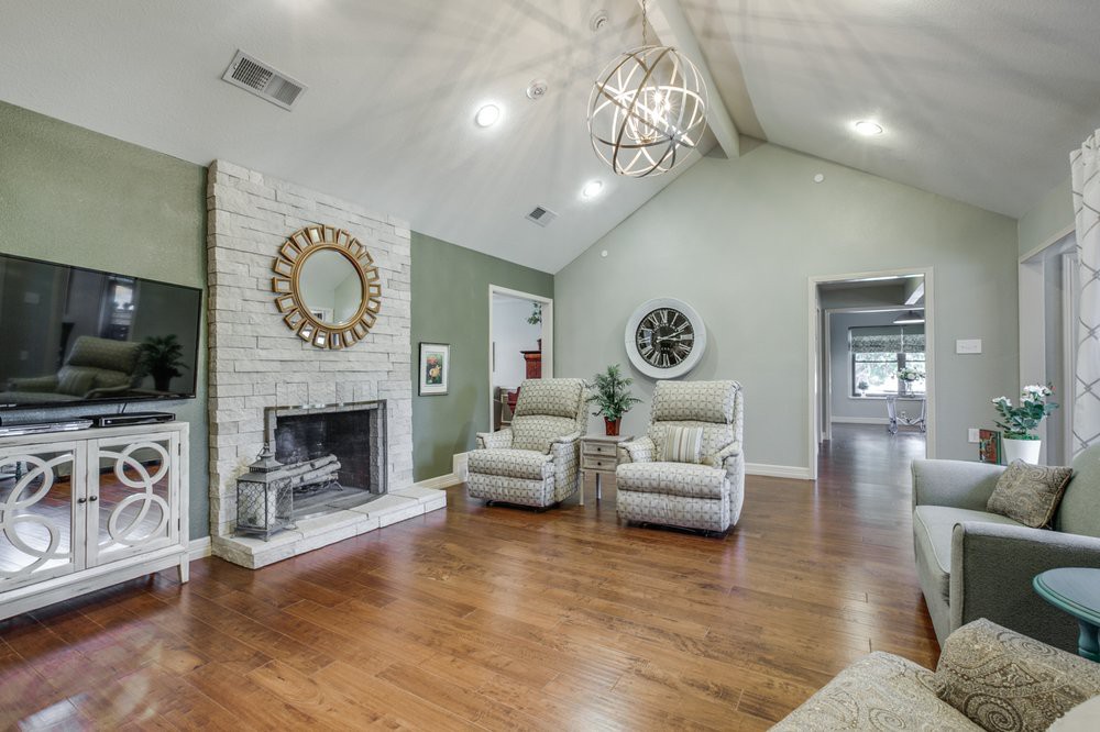 Modern living room with a vaulted ceiling, featuring a cozy fireplace and comfortable seating.