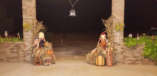 A cozy entrance adorned with autumn decorations, including pumpkins and cornstalks, welcoming the fall season.