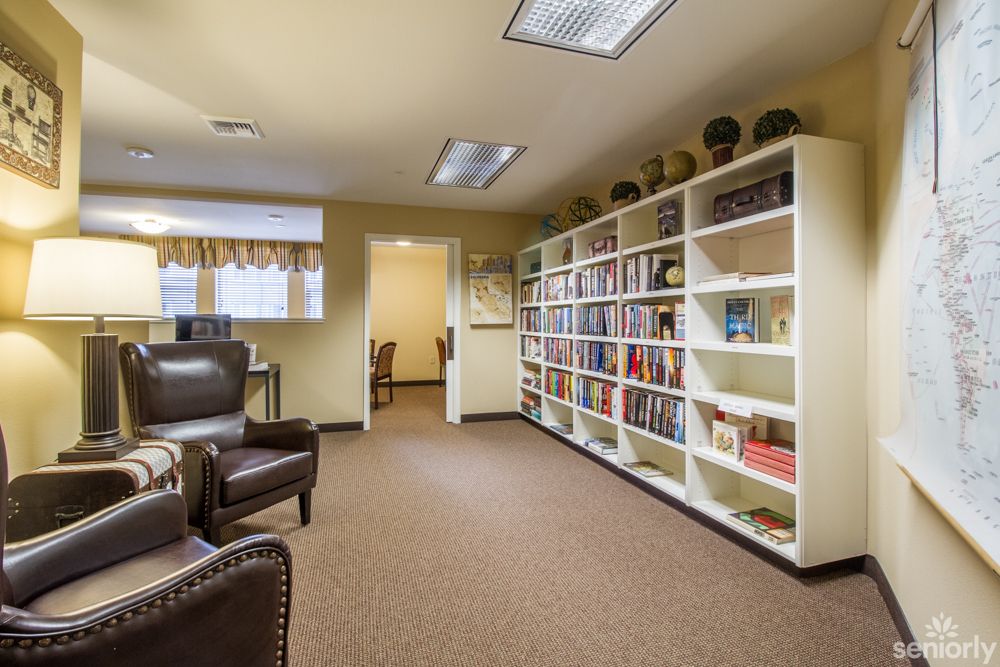 A cozy reading room with a large bookshelf and comfortable seating.