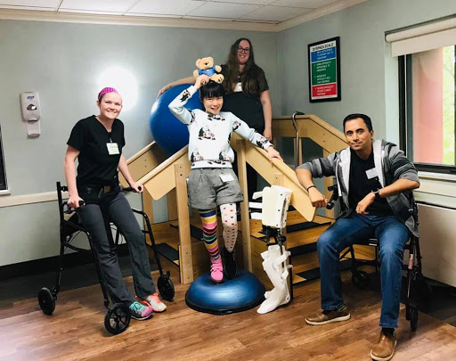 A supportive therapy session featuring a team of professionals assisting a patient in rehabilitation.