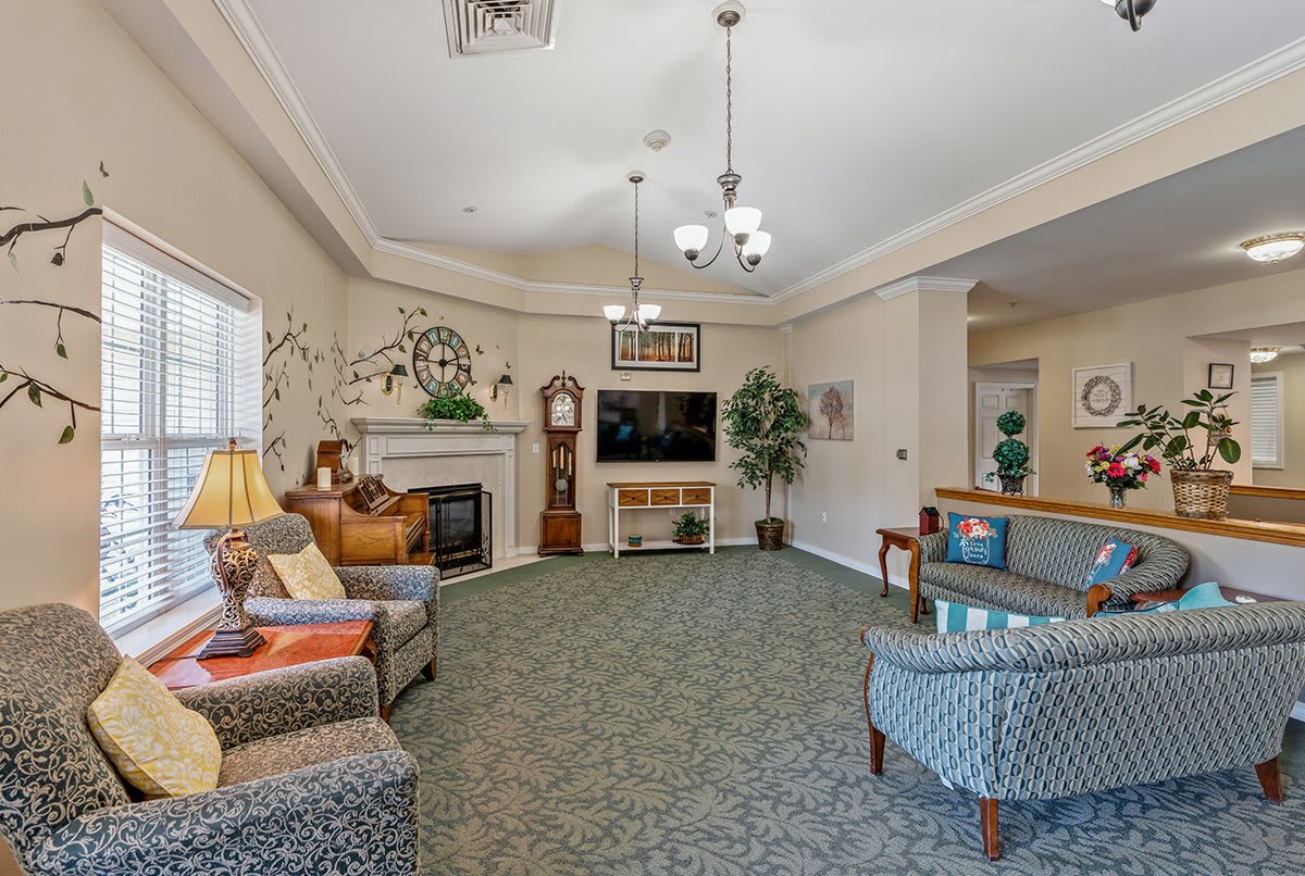 A cozy living room with comfortable seating, a television, and a fireplace, decorated in warm tones.