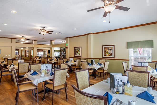 A spacious and elegantly decorated dining area with neatly arranged tables and chairs.