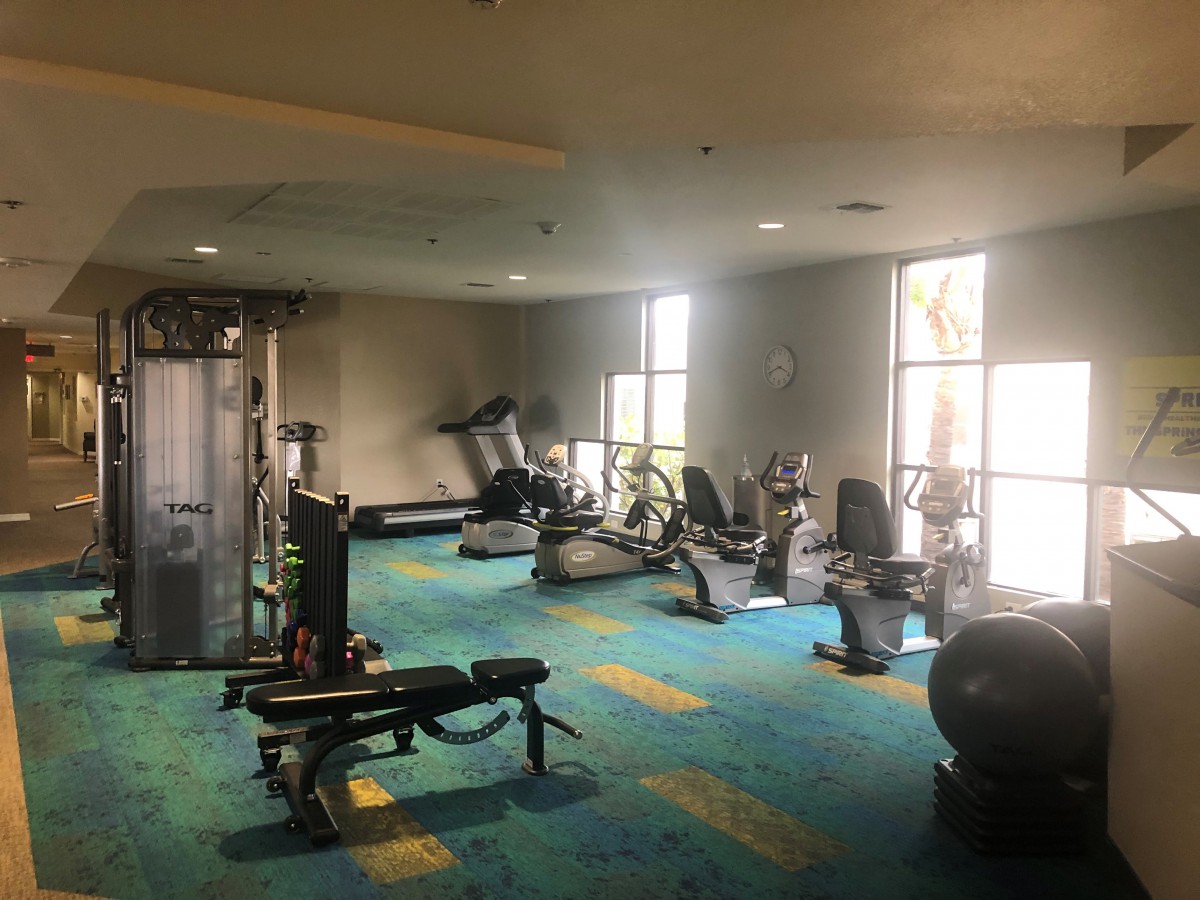 A well-equipped gym with various fitness machines and weights.