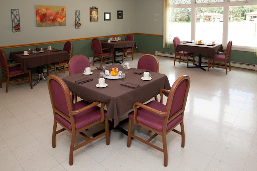 A cozy dining room setup featuring a brown table with chairs, ready for guests.
