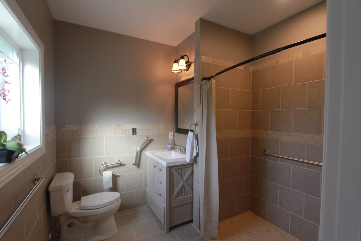 A modern bathroom with a toilet, sink, and walk-in shower.