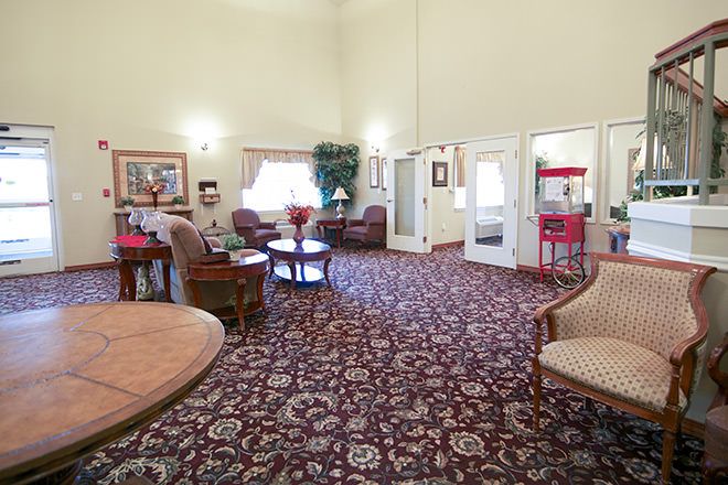 A spacious lobby area featuring comfortable seating, ornate carpet, and a popcorn machine.