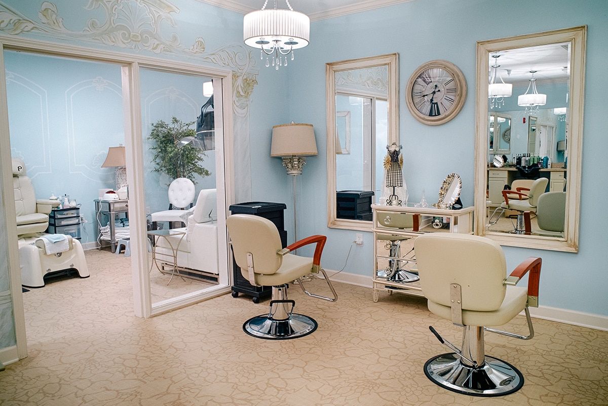 A stylish and elegantly furnished hair salon with light blue walls and chic decor.