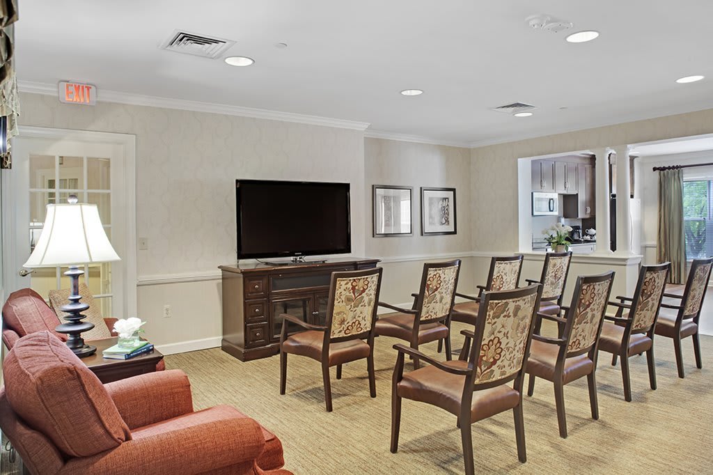 A small conference room with arranged chairs facing a television.
