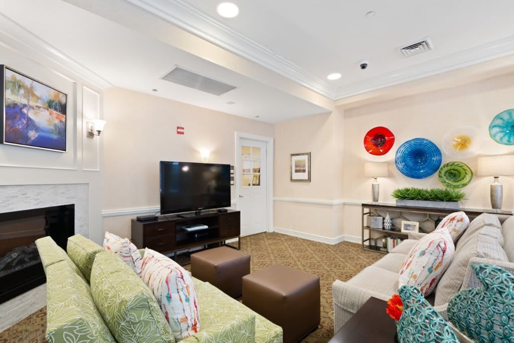 A modern living room with stylish furnishings, including a sofa, television, and colorful wall decorations.