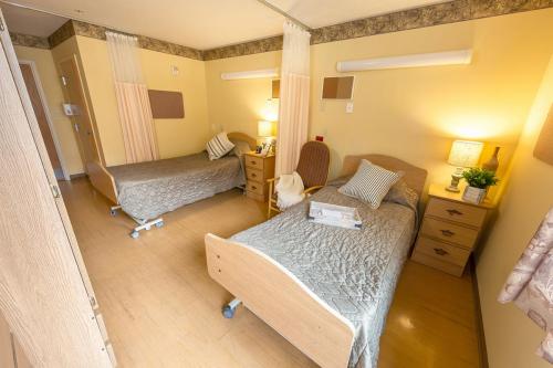 A cozy hospital room with two separate beds, designed for comfort and ease.