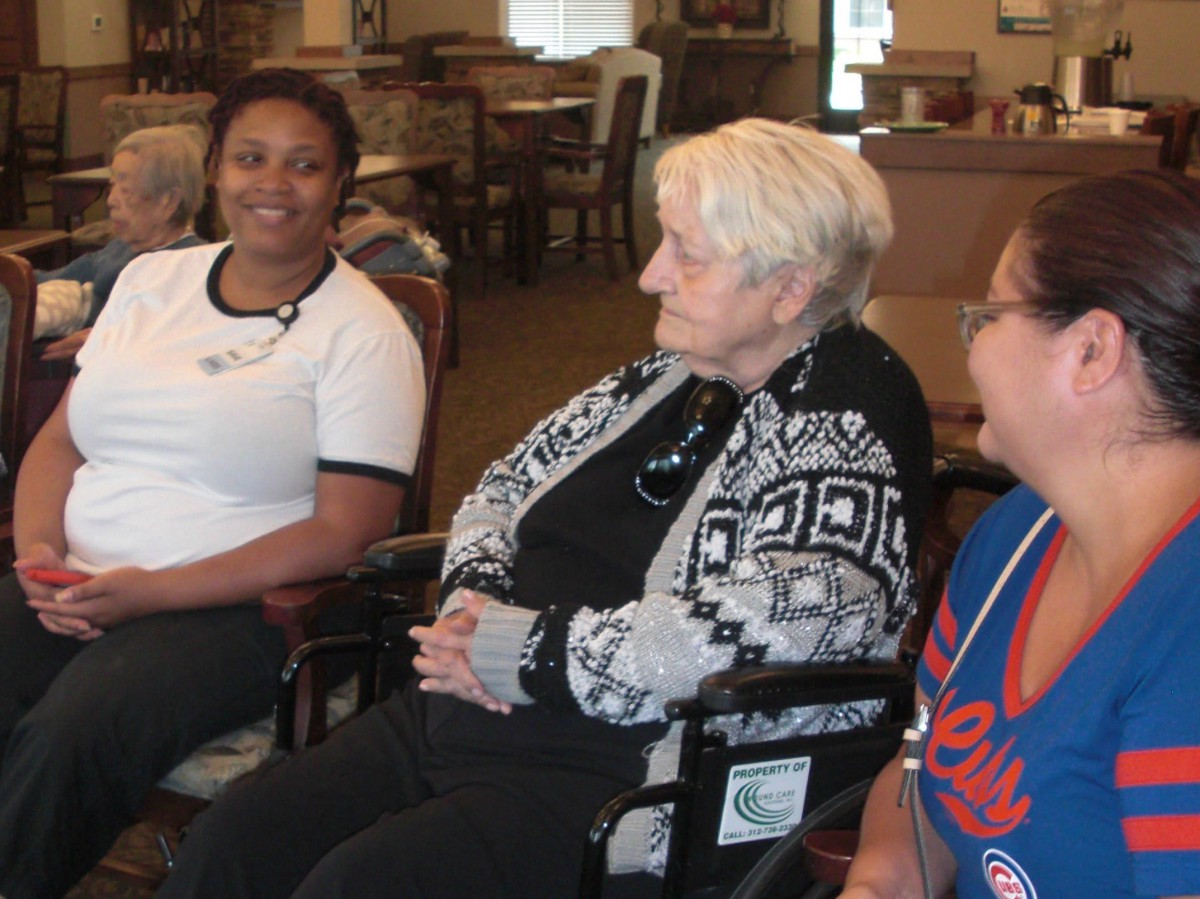 A group of people in a care home setting having a conversation.