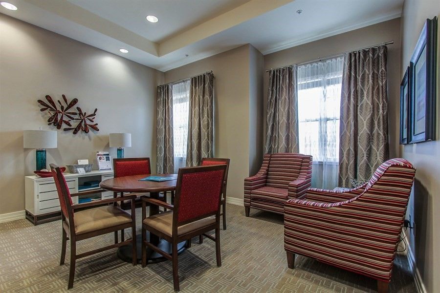 A cozy living room with comfortable chairs, a table, and elegant decor.