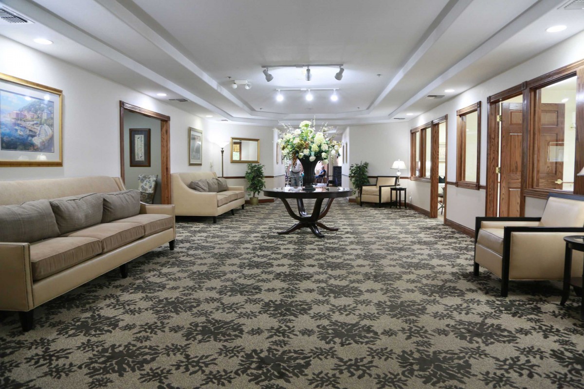 A spacious and elegantly decorated lobby with comfortable seating and a central table adorned with flowers.