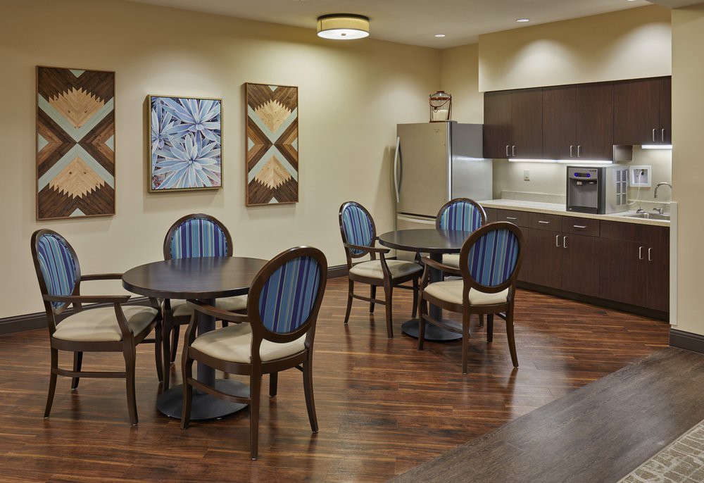 A modern kitchen and dining area with stylish furniture and artwork on the walls.