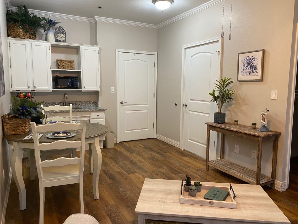 A cozy and modern combined kitchen and dining area with light-colored furniture and decor.