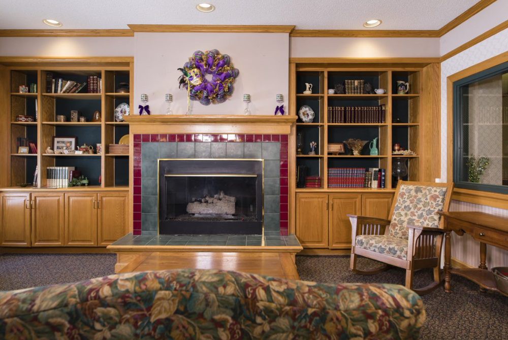 A cozy living room featuring a fireplace with surrounding bookshelves and decorative elements.
