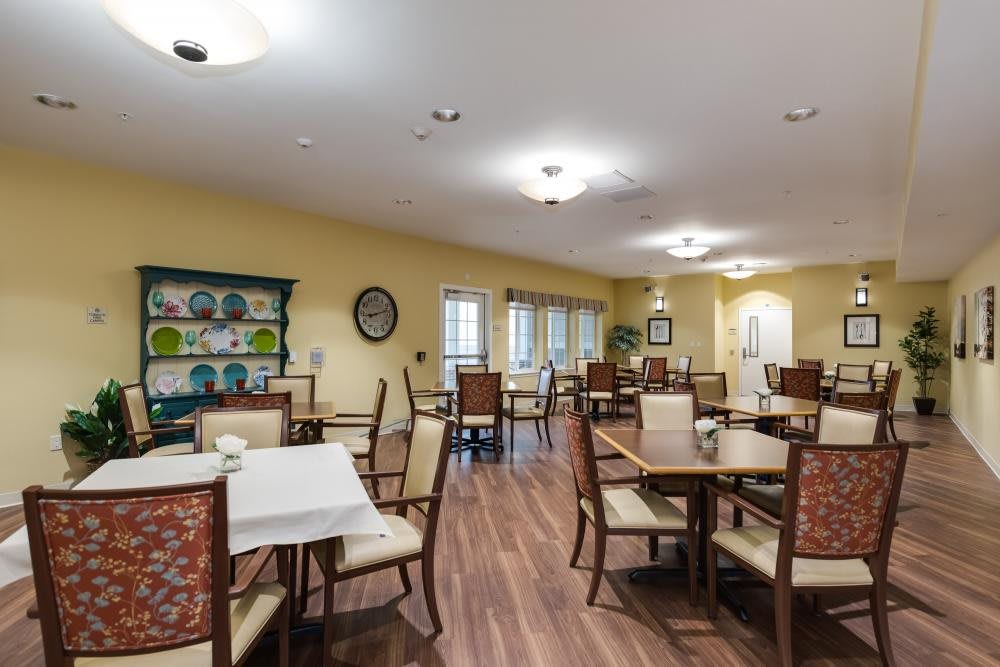 A well-lit interior dining room with arranged tables and chairs, featuring decorative elements on the walls.