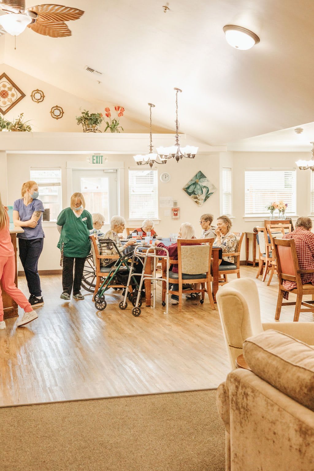 A warm and welcoming nursing home environment where caregivers interact with elderly residents.