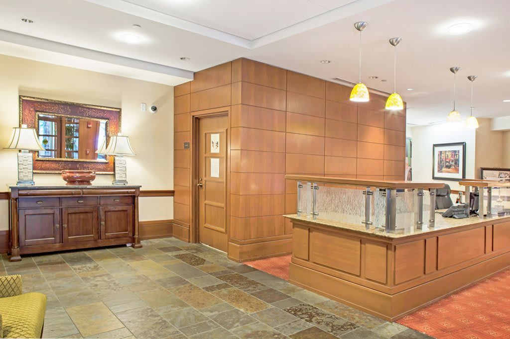 A modern hotel lobby with wooden paneling and warm lighting.