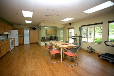 A spacious and modern kitchen with a dining area, featuring wooden flooring and contemporary furniture.