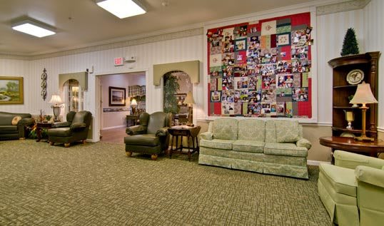 A cozy living room with comfortable seating and a photo collage on the wall.