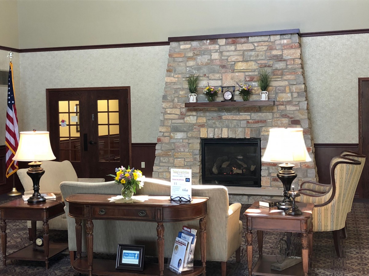 A cozy living room featuring a stone fireplace and comfortable seating with elegant lamps.